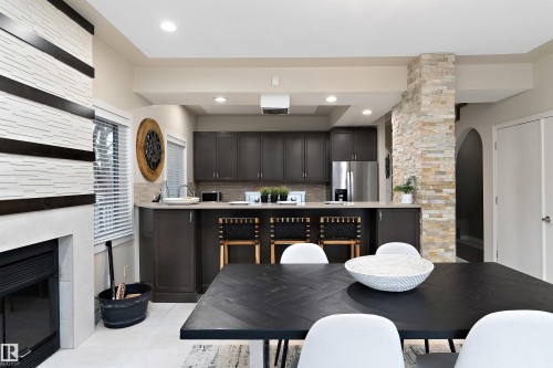 Kitchen with dark cabinetry, stainless steel appliances, and a breakfast bar - 9654 100 Street Nw, Edmonton, AB 