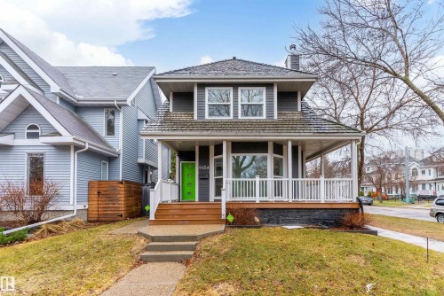 Gray-sided exterior with white trim and a green front door - 9654 100 Street Nw, Edmonton, AB 