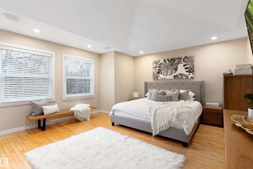 Recessed ceiling lighting, two large windows with blinds, light wood-finish flooring, and light-toned wall paint - 9654 100 Street Nw, Edmonton, AB 