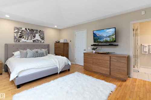 Hardwood flooring, recessed lighting, wood-finish dresser, wood-finish tallboy dresser, and a glass-enclosed shower - 9654 100 Street Nw, Edmonton, AB 