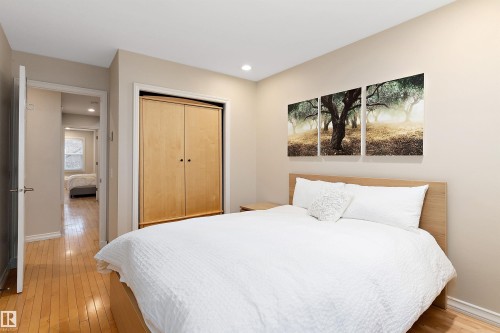 Recessed lighting, wood-finish flooring, light-toned walls, and a built-in closet with bifold doors - 9654 100 Street Nw, Edmonton, AB 