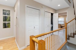 Wood-finish flooring, recessed lighting, white panel doors, and a built-in laundry center - 