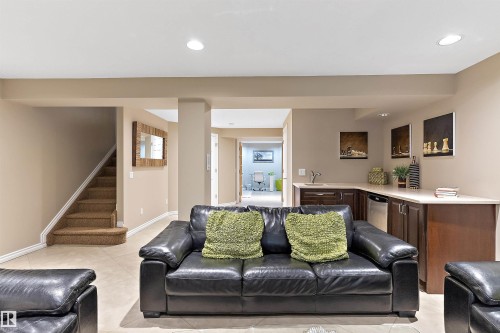 Recessed lighting, tile flooring, built-in wet bar with sink, dark wood cabinetry, and integrated dishwasher - 9654 100 Street Nw, Edmonton, AB 