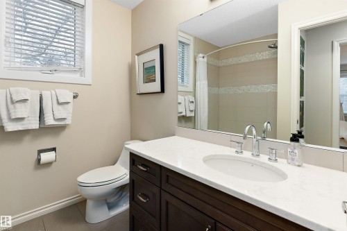 Bathroom featuring a dark wood-finish vanity with a white countertop, oval undermount sink, and chrome fixtures - 9654 100 Street Nw, Edmonton, AB 