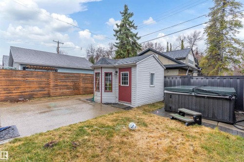 Detached shed with multiple windows, red door, and a covered spa - 9654 100 Street Nw, Edmonton, AB 