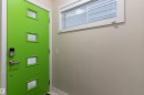 Vibrant green door featuring multiple frosted glass panels, brushed metal door hardware, and an electronic keypad entry - 9654 100 Street Nw, Edmonton, AB 