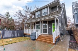 Two-story exterior with horizontal siding, covered porch, wood-finish steps, and a bright green entry door - 