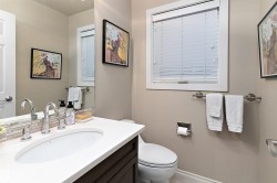 Built-in vanity with an undermount sink, dual-handle faucet, and mosaic tile backsplash - 