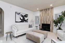 Recessed lighting, wood-look fireplace surround, built-in fireplace, two windows with blinds, and an arched entryway - 