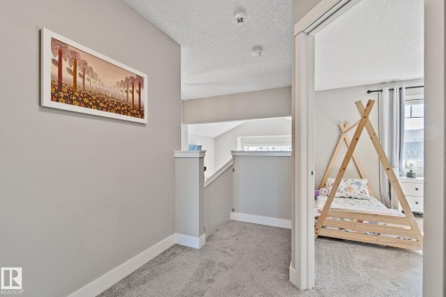 Neutral wall paint, carpeted flooring, white trim, and a clear architectural opening - 2096 Redtail Common Nw, Edmonton, AB 