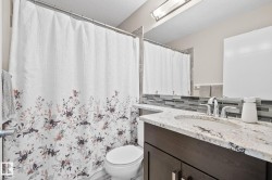 Vanity with an undermount sink, stone countertop, and mosaic tile backsplash - 