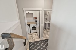 Laundry area with front-load washer and dryer, built-in cabinetry, and countertop - 