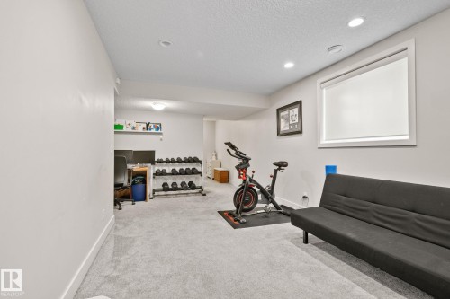 Finished Basement Recreation Room featuring polished concrete flooring, recessed ceiling lighting, and abundant natural light from large window - 2096 Redtail Common Nw, Edmonton, AB 