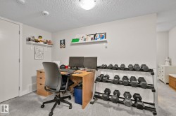 Spacious room with light gray walls, textured ceiling, and light gray carpeting - 