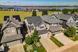 Residential property with stone accenting, attached two-car garage, and established landscaping - 