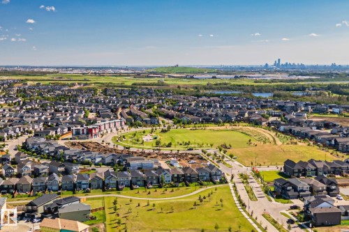 Expansive residential development featuring detached homes, green spaces, and a distant city skyline - 2096 Redtail Common Nw, Edmonton, AB 