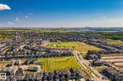 Expansive residential neighborhood featuring numerous single-family homes, wide paved streets, and abundant green spaces - 