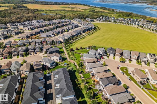 Aerial perspective of a residential neighborhood featuring diverse housing styles, established landscaping, and abundant green spaces - 2096 Redtail Common Nw, Edmonton, AB 