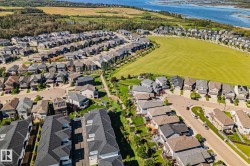 Aerial perspective of a residential neighborhood featuring diverse housing styles, established landscaping, and abundant green spaces - 