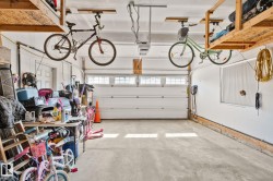 Attached garage with overhead storage shelving, automatic garage door opener, and a side access door - 