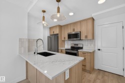 Kitchen featuring a waterfall-edge island, wood-finish cabinetry, stainless steel appliances, and white tiled backsplash - 