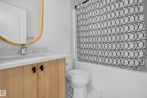 Bathroom featuring a single vanity with wood-finish cabinetry, a white countertop, and a built-in sink - #58 16231 19 Av Sw, Edmonton, AB 