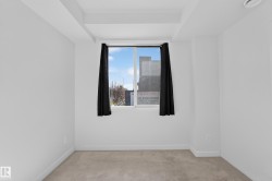 Carpeted flooring, white painted walls, and a large window - 