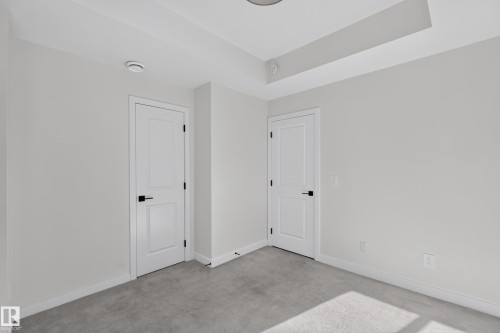 Recessed ceiling lighting, tray ceiling, neutral wall color, contemporary interior doors with black hardware, and grey carpeting - #58 16231 19 Av Sw, Edmonton, AB 