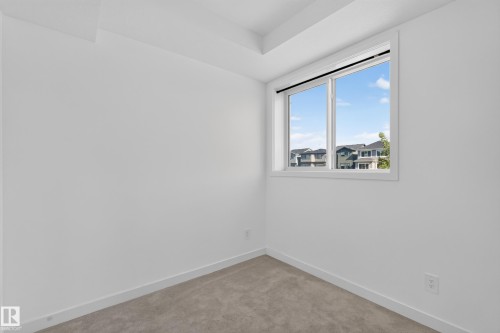 Recessed ceiling detail, carpet flooring, large window with white frame, white painted walls, and white trim - #58 16231 19 Av Sw, Edmonton, AB 