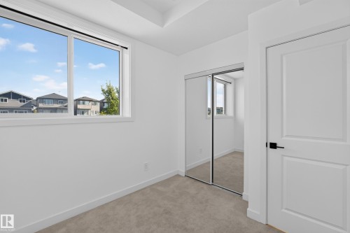 Wall-to-wall carpeting, white interior walls, and a large window with white trim - #58 16231 19 Av Sw, Edmonton, AB 
