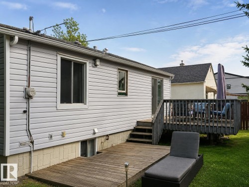 Expansive backyard featuring a wood-finish deck and additional ground-level wood-finish patio - 12130 124 Street Nw, Edmonton, AB 