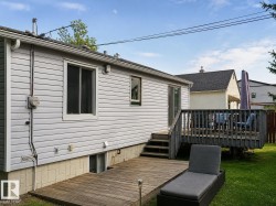 Expansive backyard featuring a wood-finish deck and additional ground-level wood-finish patio - 