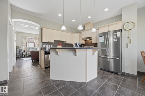 Kitchen featuring a peninsula island, stainless steel appliances, recessed lighting, and tiled flooring - #102 13825 155 Av Nw, Edmonton, AB 