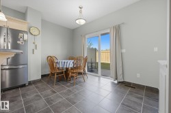 Ceramic tile flooring, sliding glass door, and a built-in kitchen peninsula with a stainless steel refrigerator - 