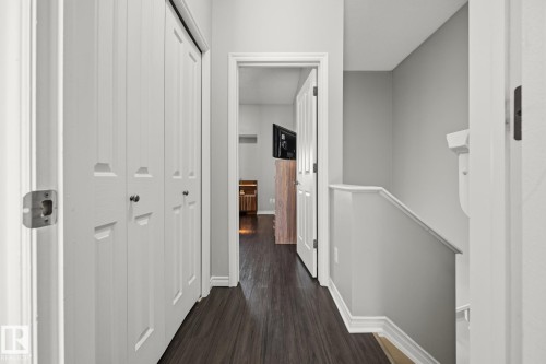 Dark wood-finish flooring with white trim - #102 13825 155 Av Nw, Edmonton, AB 