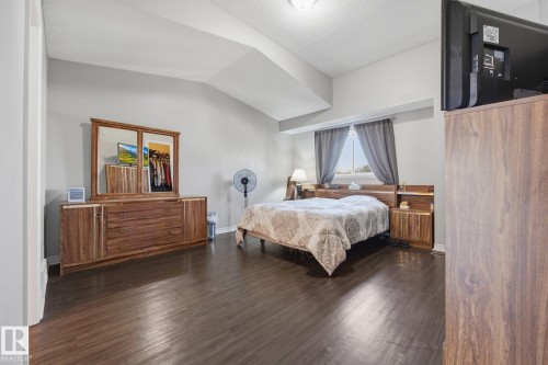 Wood-finish flooring with light gray walls and a window with curtains - #102 13825 155 Av Nw, Edmonton, AB 