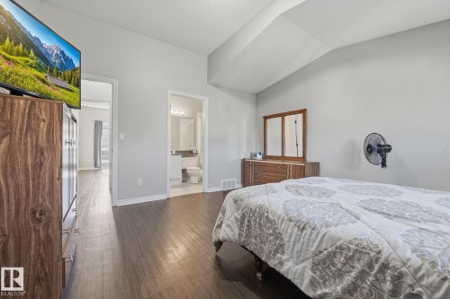 Vaulted ceilings, wood-finish flooring, light gray wall paint, and white trim - #102 13825 155 Av Nw, Edmonton, AB 