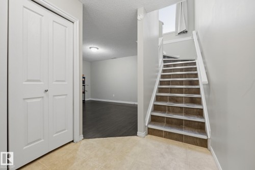 Tile flooring entry with a white bi-fold closet door - #102 13825 155 Av Nw, Edmonton, AB 