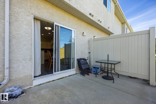 Private patio area featuring a concrete surface and privacy wall - #102 13825 155 Av Nw, Edmonton, AB 