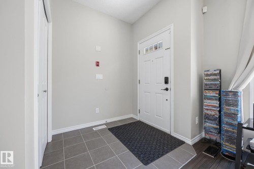 Entryway with gray tile flooring and white trim - #102 13825 155 Av Nw, Edmonton, AB 