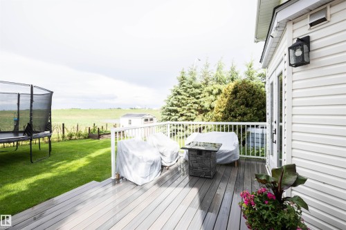 Expansive composite deck featuring white railings and dual access doors - 5502 60 Avenue, Barrhead, AB - Outdoor With Deck Patio Veranda With Exterior