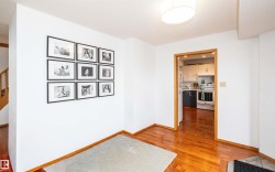 Bright interior space featuring polished wood-finish flooring, white walls, and wood trim accents - 