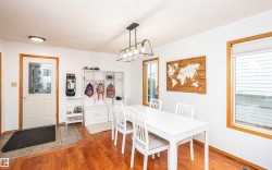 Bright interior space featuring wood-finish flooring and a contemporary linear chandelier - 