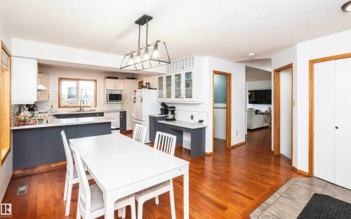Open-concept kitchen and dining area featuring rich wood-finish flooring - 5502 60 Avenue, Barrhead, AB - Indoor Photo Showing Dining Room