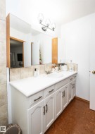 Vanity with integrated sink, white cabinetry, and brushed nickel hardware - 