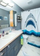 Bathroom featuring a vanity with a white countertop and dark cabinetry, an undermount sink, and a wall-mounted medicine cabinet - 