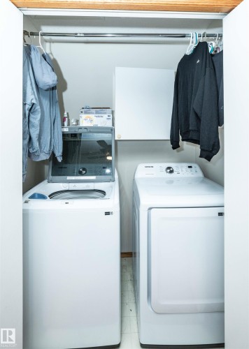 Dedicated laundry area featuring a top-loading washing machine and front-loading dryer - 5502 60 Avenue, Barrhead, AB - Indoor Photo Showing Laundry Room