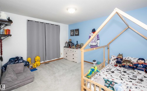 Room featuring light blue and white painted walls, wall-to-wall carpeting, and wood-finish baseboards - 5502 60 Avenue, Barrhead, AB - Indoor Photo Showing Bedroom