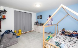 Room featuring light blue and white painted walls, wall-to-wall carpeting, and wood-finish baseboards - 