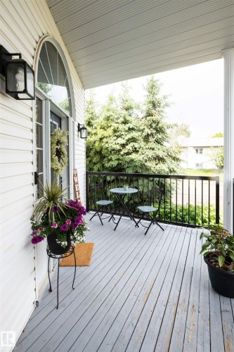 Covered front porch featuring white siding and a light-colored wood-finish deck - 5502 60 Avenue, Barrhead, AB - Outdoor With Deck Patio Veranda With Exterior